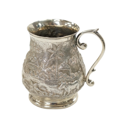 827 - An Indian embossed white metal baluster mug, height 77mm, 94 grams. Condition - poor to fair