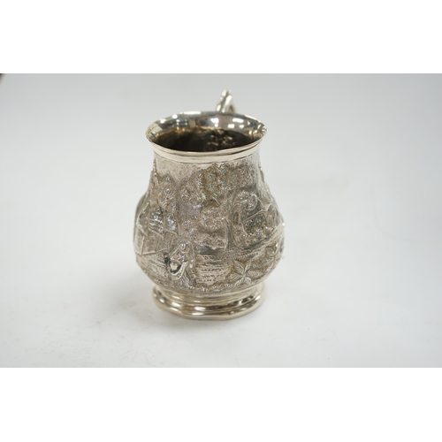 827 - An Indian embossed white metal baluster mug, height 77mm, 94 grams. Condition - poor to fair