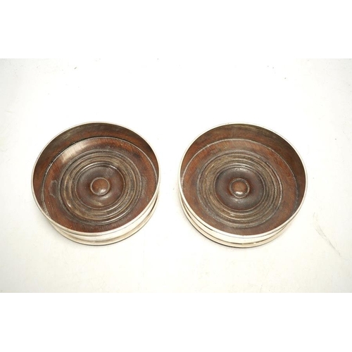 843 - A pair of 19th century Continental white metal wine coasters, inset with turned mahogany bases, 12.5... 