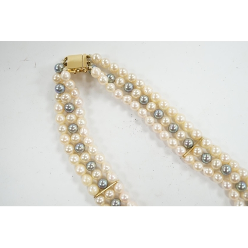 902 - A modern triple strand two colour cultured pearl necklace, with yellow metal clasp and detachable ye... 