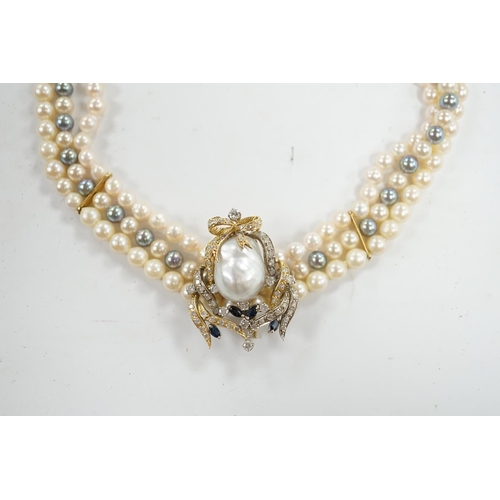 902 - A modern triple strand two colour cultured pearl necklace, with yellow metal clasp and detachable ye... 