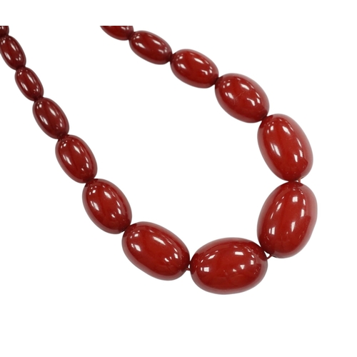 904 - A single strand graduated simulated cherry amber bead necklace, 68cm, gross weight 52 grams. Conditi... 