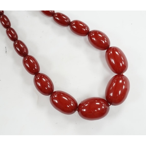 904 - A single strand graduated simulated cherry amber bead necklace, 68cm, gross weight 52 grams. Conditi... 