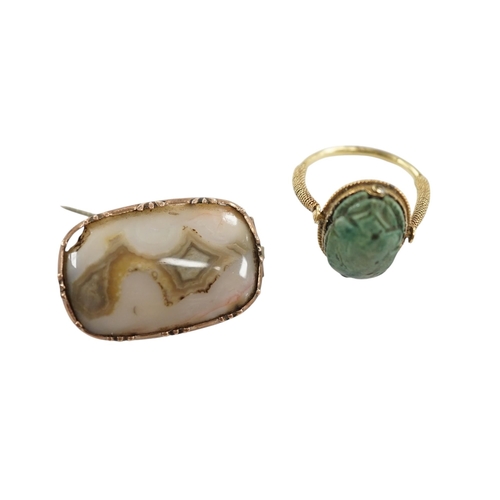 910 - An antique yellow metal 'Scarab' ring and a banded agate set brooch. Condition - poor to fair