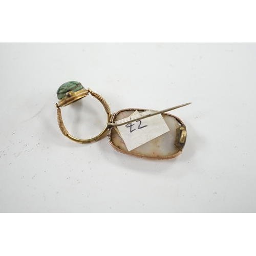 910 - An antique yellow metal 'Scarab' ring and a banded agate set brooch. Condition - poor to fair