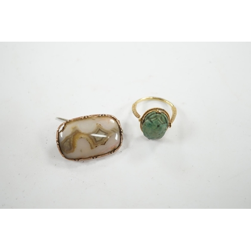 910 - An antique yellow metal 'Scarab' ring and a banded agate set brooch. Condition - poor to fair