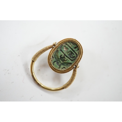 910 - An antique yellow metal 'Scarab' ring and a banded agate set brooch. Condition - poor to fair