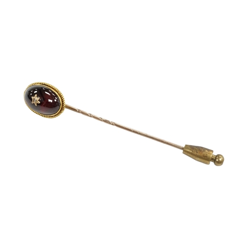 912 - A cased Victorian yellow metal, oval cabochon garnet and diamond chip set stick pin, overall 77mm. C... 