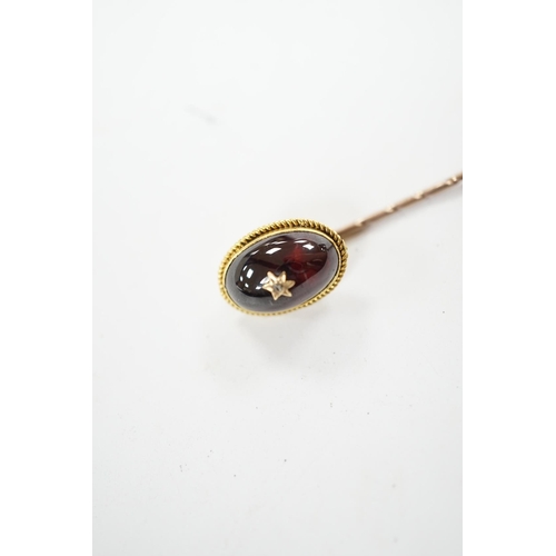 912 - A cased Victorian yellow metal, oval cabochon garnet and diamond chip set stick pin, overall 77mm. C... 