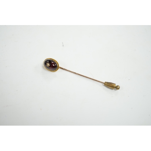 912 - A cased Victorian yellow metal, oval cabochon garnet and diamond chip set stick pin, overall 77mm. C... 