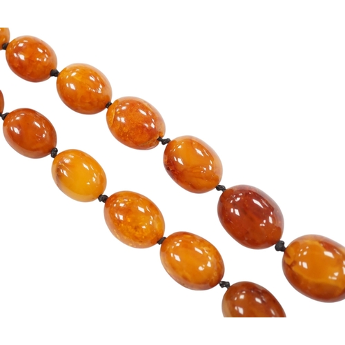 922 - A single strand graduated oval amber bead necklace, 76cm, gross weight 107 grams. Condition - poor... 