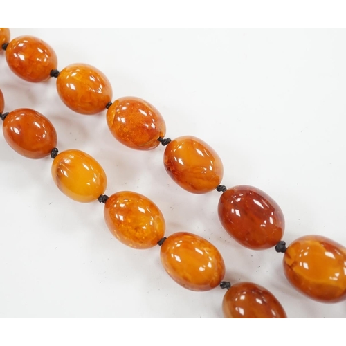 922 - A single strand graduated oval amber bead necklace, 76cm, gross weight 107 grams. Condition - poor... 