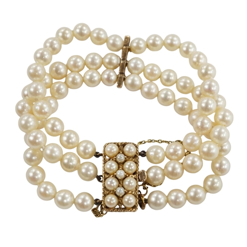 943 - A triple strand cultured pearl necklace, with 9ct and cultured pearl clasp and spacer, 18cm. Conditi... 