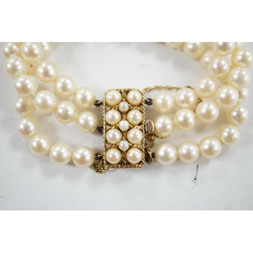 943 - A triple strand cultured pearl necklace, with 9ct and cultured pearl clasp and spacer, 18cm. Conditi... 