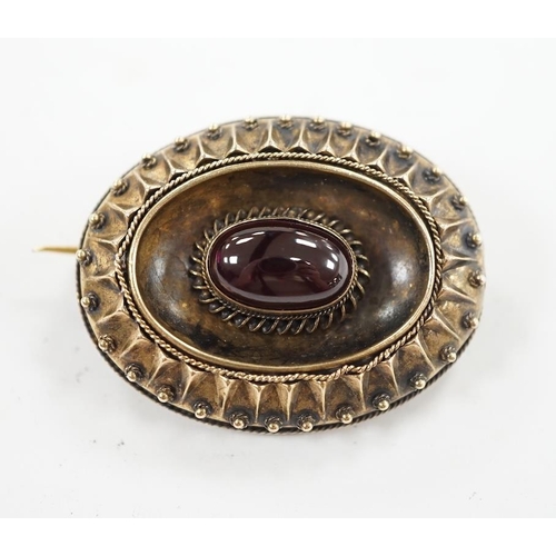 952 - A Victorian yellow metal and single stone oval cabochon garnet set oval brooch, with glazed back, 33... 