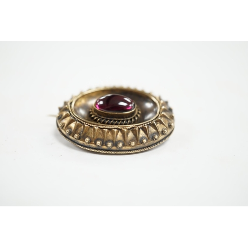 952 - A Victorian yellow metal and single stone oval cabochon garnet set oval brooch, with glazed back, 33... 