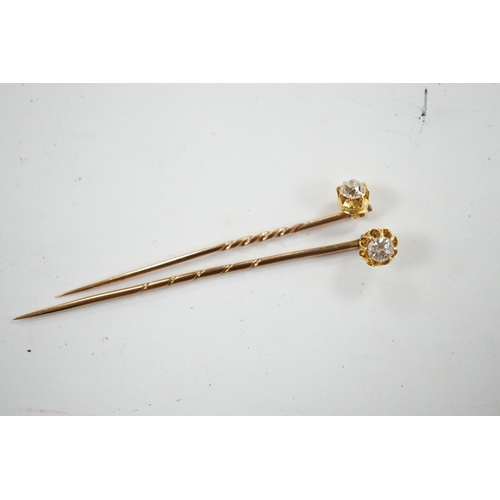 953 - Two early 20th century yellow metal and solitaire diamond set stick pins, 65mm and a dress stud. Con... 