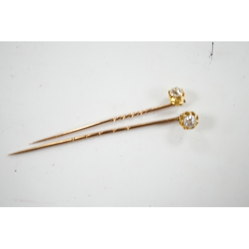 953 - Two early 20th century yellow metal and solitaire diamond set stick pins, 65mm and a dress stud. Con... 