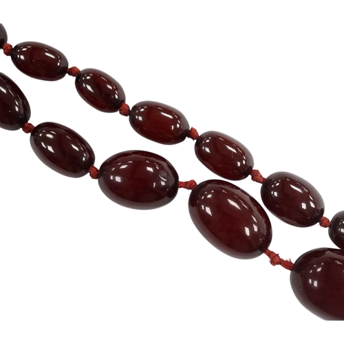 976 - A single strand graduated simulated cherry amber bead necklace, gross weight 66 grams (string a.f.) ... 