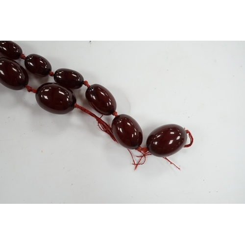 976 - A single strand graduated simulated cherry amber bead necklace, gross weight 66 grams (string a.f.) ... 