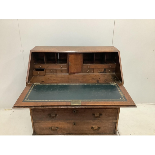 1131 - A George III oak bureau, with four long graduated drawers, on bracket feet, width 92cm, depth 50cm, ... 