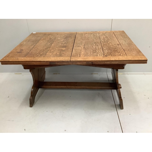 1142 - An oak draw leaf dining table, the shaped end standards united by a flat stretcher, width 130cm, dep... 