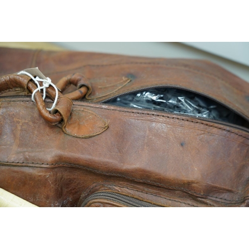 1445 - A leather sports holdall, with squash racket. Condition - poor to fair