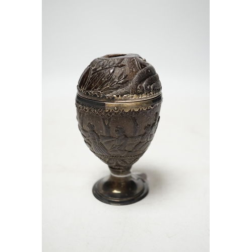 1848 - An early 19th century white metal mounted coconut cup, carved with continuous scene of figures, heig... 