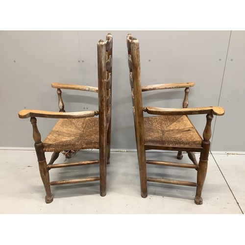 60 - A pair of 19th century Provincial fruitwood rush seated ladder back elbow chairs, later painted, wid... 