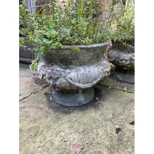 16 - A set of four reconstituted stone circular bulbous garden urns moulded with lion masks and swags, 50... 