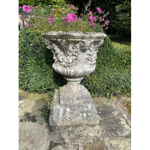 17 - Three reconstituted stone campana shaped garden urns moulded with fruit, on square bases, 59cm diame... 