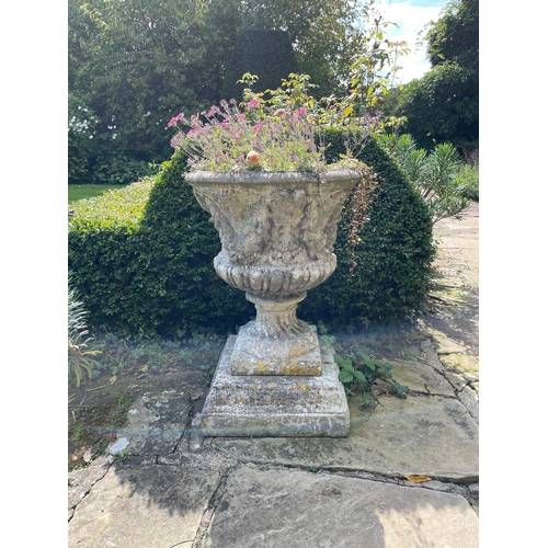 17 - Three reconstituted stone campana shaped garden urns moulded with fruit, on square bases, 59cm diame... 