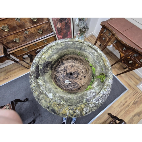 18 - A reconstituted stone bird bath with central bowl and dolphin brackets, on a circular plinth, 136cm ... 