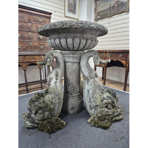 18 - A reconstituted stone bird bath with central bowl and dolphin brackets, on a circular plinth, 136cm ... 