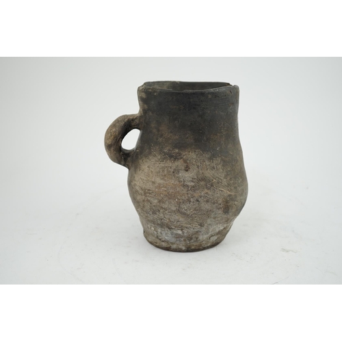 23 - An archaic pottery jug, Iron Age, excavated in Britain, 16cm wide over handle, 18.5cm high