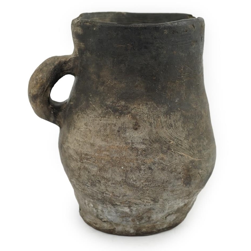 23 - An archaic pottery jug, Iron Age, excavated in Britain, 16cm wide over handle, 18.5cm high