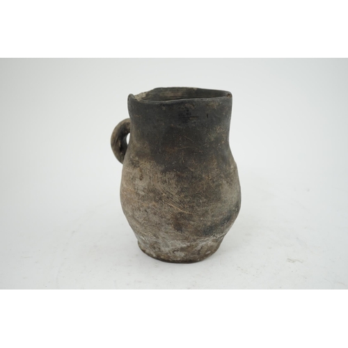 23 - An archaic pottery jug, Iron Age, excavated in Britain, 16cm wide over handle, 18.5cm high