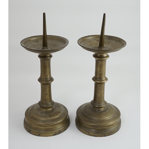 45 - A pair of 16th century bell metal pricket candlesticks with ring turned stems and feet, 16cm diamete... 