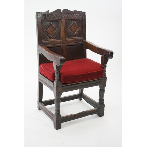 48 - A 17th century and later oak Wainscot elbow chair with quadruple panelled back and solid seat, on tu... 