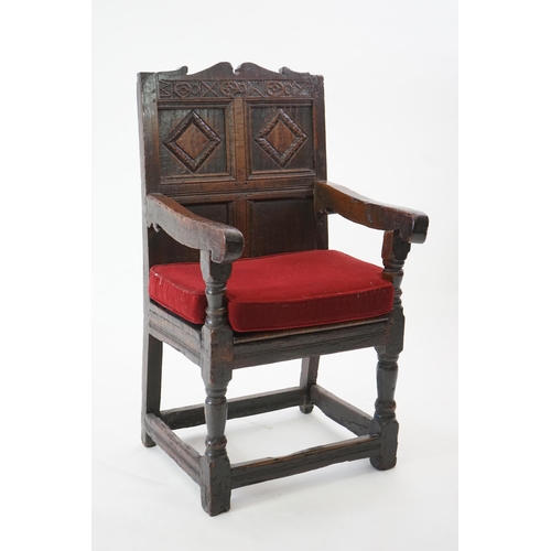 48 - A 17th century and later oak Wainscot elbow chair with quadruple panelled back and solid seat, on tu... 