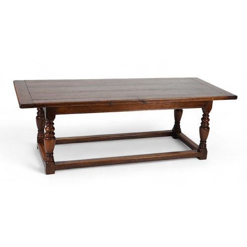 5 - A 17th century style oak refectory table with cleated planked top on turned baluster and squared all... 