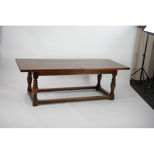 5 - A 17th century style oak refectory table with cleated planked top on turned baluster and squared all... 