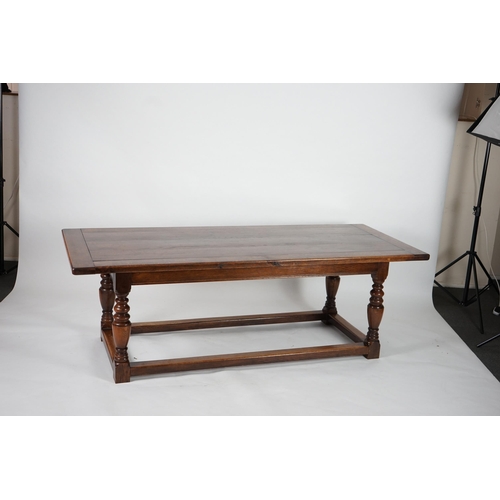 5 - A 17th century style oak refectory table with cleated planked top on turned baluster and squared all... 