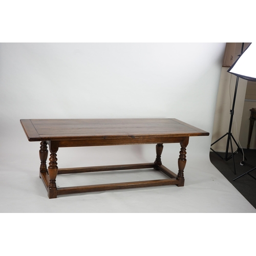 5 - A 17th century style oak refectory table with cleated planked top on turned baluster and squared all... 