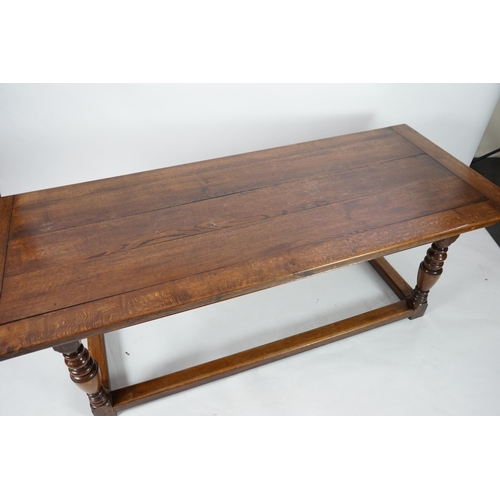 5 - A 17th century style oak refectory table with cleated planked top on turned baluster and squared all... 