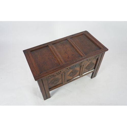 51 - A 17th century oak coffer with triple panelled top, candle box and rosette carved front, 95cm wide, ... 