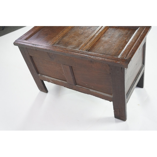 51 - A 17th century oak coffer with triple panelled top, candle box and rosette carved front, 95cm wide, ... 