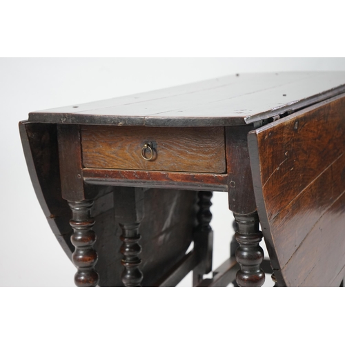 66 - A 17th century and later oak gateleg table with oval drop leaf top and single frieze drawer, on bobb... 