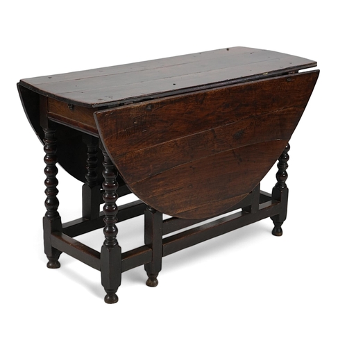 66 - A 17th century and later oak gateleg table with oval drop leaf top and single frieze drawer, on bobb... 