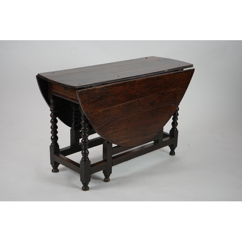 66 - A 17th century and later oak gateleg table with oval drop leaf top and single frieze drawer, on bobb... 